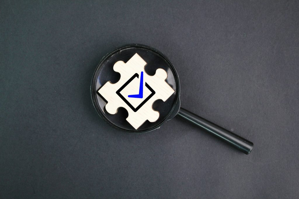 magnifying glass and wooden puzzle with correct sign icon.