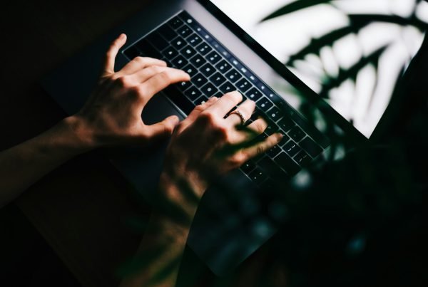 Woman typing on laptop keyboard at the night, close-up.